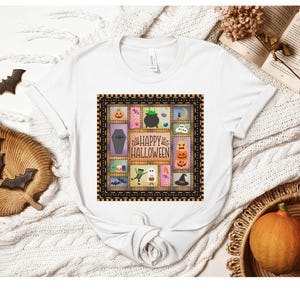 May include: A white short-sleeve t-shirt featuring a central graphic print with the text "HAPPY HALLOWEEN" surrounded by a grid of colorful illustrations including a pumpkin, a coffin, a cauldron, a ghost, and a witch hat within a patterned border.