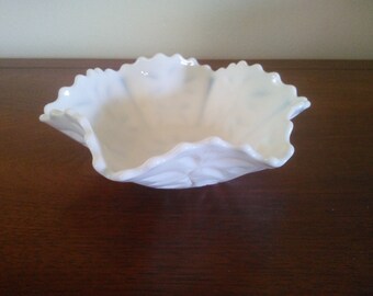 May include: A white milk glass bowl with a scalloped edge. The bowl is empty and has a smooth, glossy finish.
