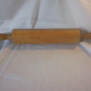 May include: A wooden rolling pin with natural wood handles. The rolling pin is approximately 18 inches long.