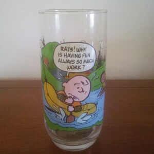May include: A glass with a Peanuts cartoon character on it. The character is in a canoe and says "Rats! Why is having fun always so much work?"