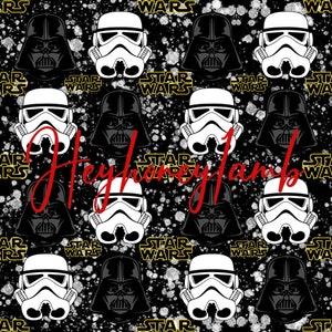 Könnte beinhalten: Ein sich wiederholendes Schwarz-Weiß-Muster mit Darth Vader- und Stormtrooper-Helmen auf schwarzem Hintergrund mit weißen Spritzern. Der Text "STAR WARS" wird in Gelb wiederholt.