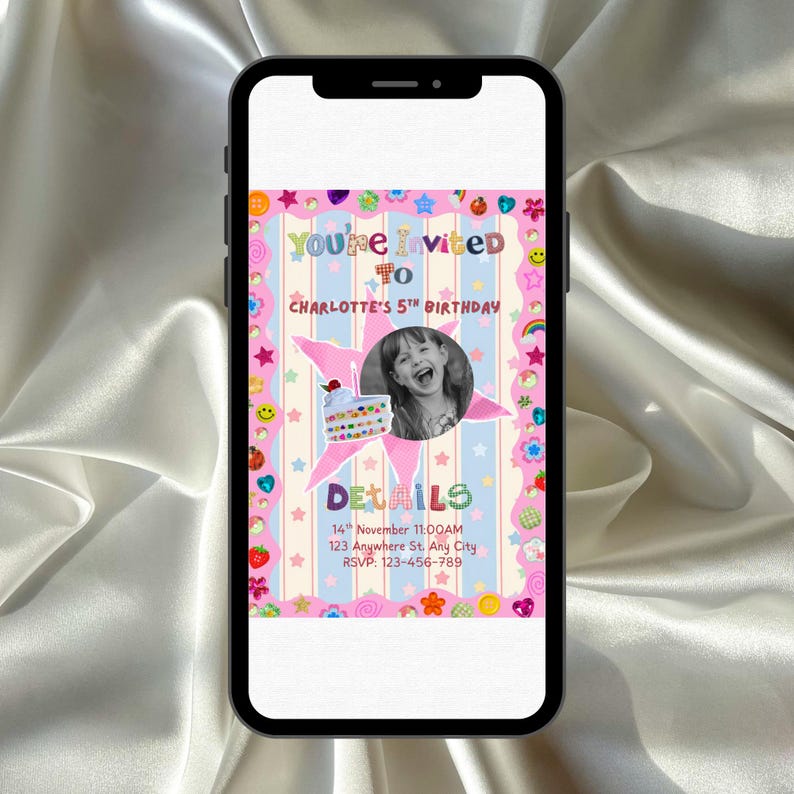 A smartphone rests on a surface while displaying a bright, playful birthday invitation. The design features pastel stripes with stars, hearts, smiley faces, flowers, and other fun sticker‑style decorations. In the center, a round black‑and‑white photo of a smiling child appears beside a cute birthday cake illustration. The overall look is colorful, crafty, and whimsical, perfect for a child’s celebration.