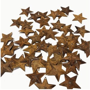 May include: A collection of numerous small, five-pointed metal stars with a weathered, rusted brown finish. Each star features a central raised ridge and a small hole at one of the points, scattered across a plain white background.