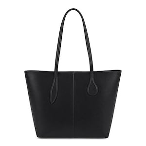May include: A solid black tote bag featuring a structured trapezoidal silhouette, a vertical center seam, and two long, slender shoulder straps attached with teardrop-shaped base reinforcements. The bag has a smooth, matte finish throughout.