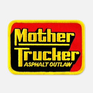 May include: A rectangular embroidered patch with a yellow border. The background is split between red and black. The text "Mother Trucker" is in large yellow letters, and the text "ASPHALT OUTLAW" is in smaller yellow letters below it.