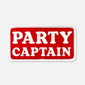 Puede incluir: Un parche rectangular bordado con un fondo rojo vibrante y un borde blanco. El texto PARTY CAPTAIN est&aacute; cosido en letras may&uacute;sculas blancas y negritas en el centro del parche, con un estilo de fuente claro y f&aacute;cil de leer.