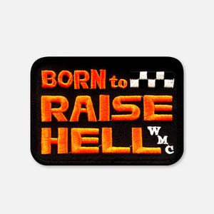 Könnte beinhalten: Ein rechteckiger bestickter Aufnäher mit schwarzem Hintergrund und orangefarbenem Text, der BORN to RAISE HELL lautet. Der Aufnäher zeigt ein schwarz-weißes Zielflaggenmotiv in der oberen rechten Ecke und die weißen Buchstaben WMC vertikal gestapelt.