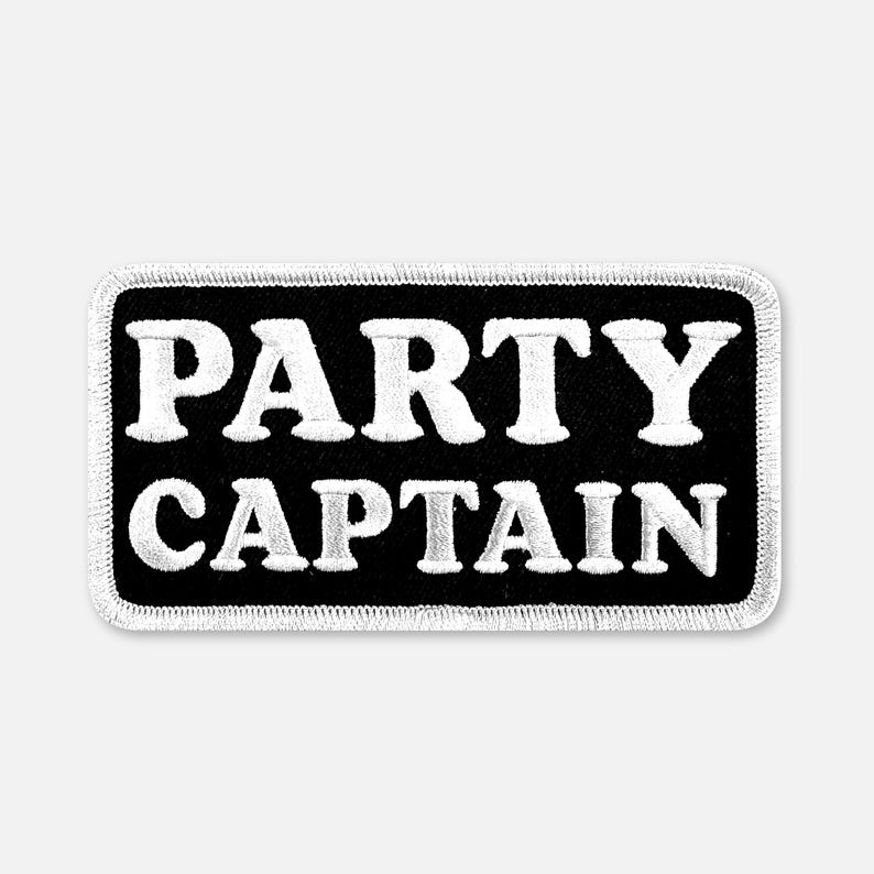 Puede incluir: Un parche rectangular bordado con fondo negro y borde blanco. El texto PARTY CAPTAIN est&aacute; bordado en letras may&uacute;sculas blancas y negritas en el centro del parche. El dise&ntilde;o presenta una est&eacute;tica limpia y de alto contraste.