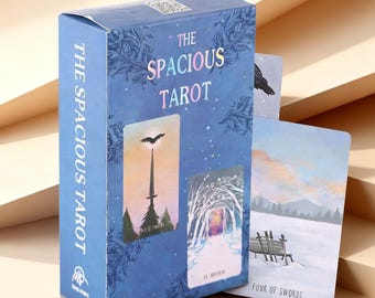 May include: A blue tarot card deck box titled The Spacious Tarot with decorative floral patterns. The box displays two card illustrations, one showing a sword and bird, the other a snowy path. A Four of Swords card stands beside the box.