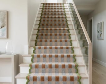 May include: A staircase runner featuring a checkered pattern in shades of tan, gray, and rust orange. The runner has a distinct scalloped edge finished with a vibrant green border, covering the center of the white wooden stairs in a home interior.