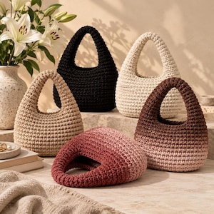 Peut inclure: Une collection de cinq petits sacs à main en crochet de forme arrondie avec des anses intégrées. Les sacs sont présentés en noir uni, crème uni, beige uni, un dégradé marron et un dégradé rose, affichant tous un motif de maille texturé.
