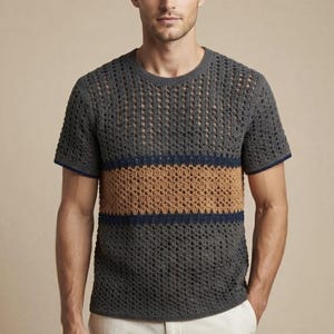 May include: A short-sleeved crew neck shirt featuring an open-knit crochet texture. The garment is primarily dark gray with a wide horizontal band of tan across the chest, bordered by thin navy blue stripes at the top and bottom of the tan section.