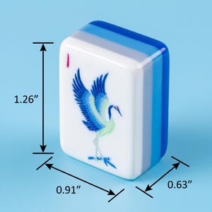 May include: A white mahjong tile featuring a blue and green crane illustration and a small red mark. The tile has blue and white layered sides and measures 3.2 cm in height, 2.31 cm in width, and 1.6 cm in depth as indicated by the dimension arrows.