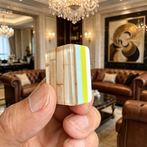 Puede incluir: Un bloque rectangular que presenta un patr&oacute;n de veta de madera en un lado, seguido de una franja vertical azul claro y una franja de color amarillo ne&oacute;n brillante en el borde. El objeto tiene un acabado liso y brillante con esquinas redondeadas.