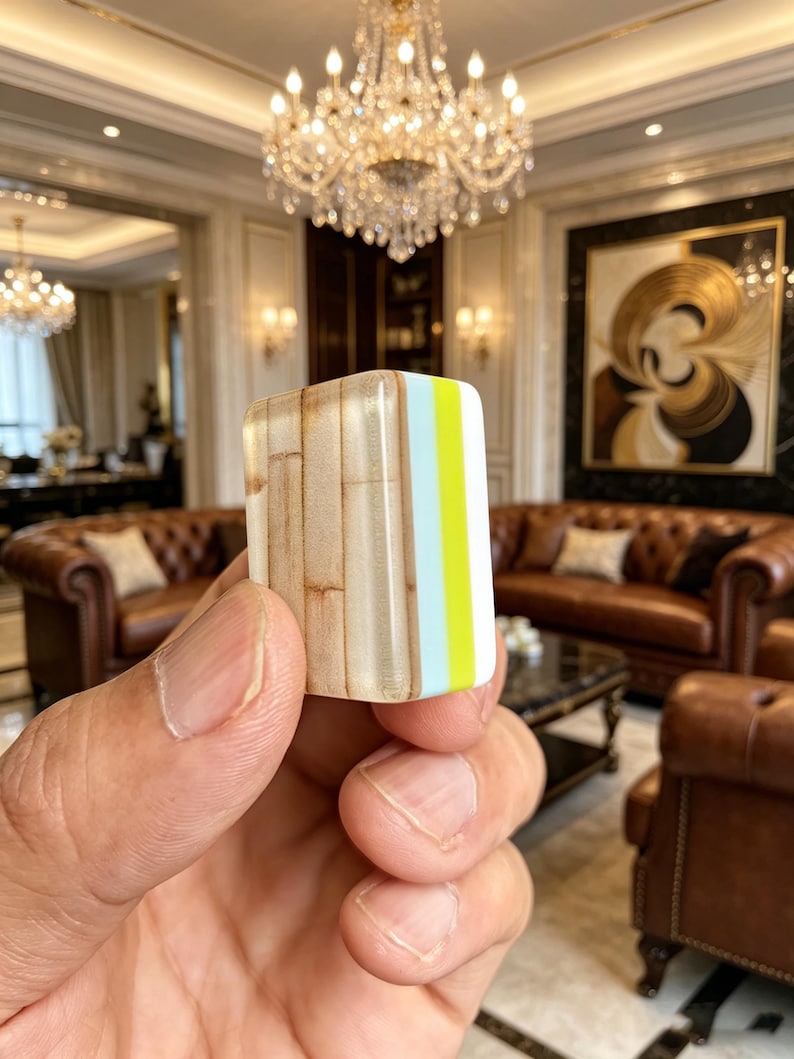 Puede incluir: Un bloque rectangular que presenta un patr&oacute;n de veta de madera en un lado, seguido de una franja vertical azul claro y una franja de color amarillo ne&oacute;n brillante en el borde. El objeto tiene un acabado liso y brillante con esquinas redondeadas.