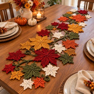 May include: A crochet table runner featuring a sprawling vine design adorned with numerous maple leaves in shades of deep red, burnt orange, golden yellow, olive green, and cream, arranged in a dense, interconnected pattern across the centre.