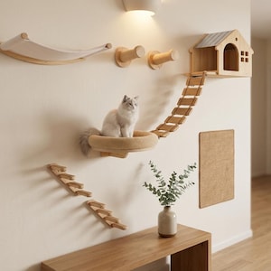 Può includere: Un set di attività per gatti montato a parete composto da un'amaca in tessuto chiaro, due pioli cilindrici in legno, una struttura a casetta in legno con tetto, una scala sospesa in legno, una piattaforma circolare imbottita e due serie di gradini in legno.