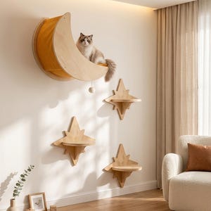 Può includere: Un set di mobili da parete per gatti composto da un grande trespolo in legno a forma di mezzaluna con interno in tessuto giallo e tre piattaforme in legno a forma di stella. Un gatto soffice è seduto all'interno del trespolo.