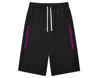 Puede incluir: Pantalones cortos negros con cintura elástica y cordones blancos. La pierna izquierda muestra el texto rosa "MATERIAL DISCIPLINE" y la derecha el texto rosa "EMOTIONAL INTELLIGENCE", ambos acompañados por un pequeño símbolo de flecha.