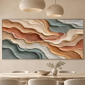 May include: A large rectangular wall art piece featuring thick, textured impasto paint strokes in horizontal, wavy layers of terracotta, beige, cream, and muted blue-grey, creating a dimensional landscape effect on a flat canvas surface.