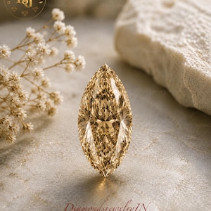 Peut inclure: Un diamant taille marquise de couleur champagne présentant une surface à facettes qui reflète la lumière. La pierre précieuse est positionnée verticalement, affichant une forme ovale pointue avec une teinte brun doré et des reflets internes.