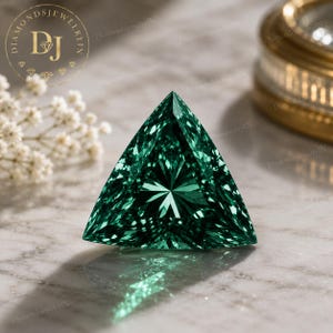 Pode incluir: Uma pedra preciosa solta com lapidação trillion de cor verde esmeralda profunda e vibrante, com uma superfície altamente facetada que cria um padrão de reflexos de luz em forma de estrela. A pedra tem uma forma triangular com cantos afiados.