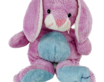 May include: A plush stuffed animal in the shape of a rabbit with soft purple fur. The rabbit features long floppy ears with white inner lining, a white muzzle, a pink nose, and black eyes. It has a light blue belly and light blue feet.