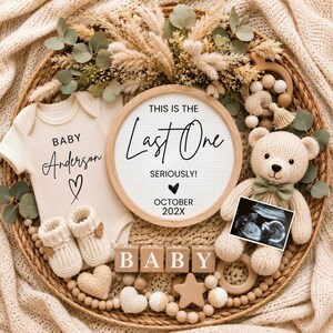 May include: A cream-colored baby bodysuit with the text Baby Anderson and a heart, a round letter board reading This is the Last One Seriously! October 202X, a knit teddy bear, baby booties, wooden blocks spelling BABY, and a sonogram photo.