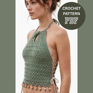 May include: An olive green crochet halter top featuring a keyhole neckline, a textured stitch pattern, and light-colored lace-up side ties. The bottom hem is finished with a row of small wooden beads. Text reads: CROCHET PATTERN PDF.