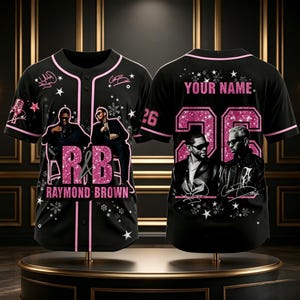 May include: A black baseball jersey with pink trim featuring graphics of two men in suits, the text R&B, RAYMOND BROWN, and YOUR NAME with the number 26. The design includes pink glitter accents, white stars, and snowflake patterns on the front and back.