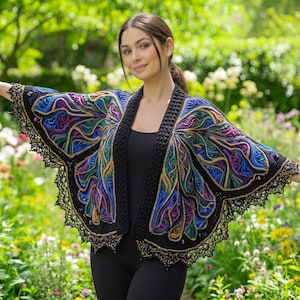 May include: A crochet butterfly wing shawl featuring vibrant shades of blue, purple, green, and gold yarn. The garment has a solid black textured border along the front opening and a delicate black lace trim with small beads along the edges.