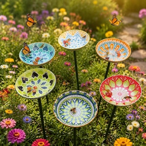 Peut inclure: Cinq tuteurs de jardin décoratifs composés de coupelles circulaires peu profondes aux motifs complexes de style mandala dans des tons de bleu, vert, orange et rouge, montés sur de fines tiges métalliques au milieu de fleurs en pleine floraison.