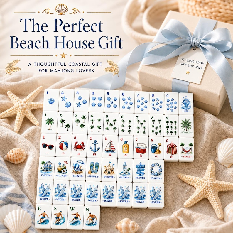 May include: A set of white mahjong tiles featuring colorful coastal illustrations including seashells, palm trees, beach gear, and surfboards. The tiles are arranged in rows alongside a gift box with a light blue ribbon and a tag reading STYLING PROP GIFT BOX ONLY.