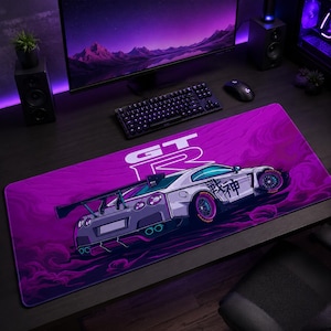 Pode incluir: Um tapete de secretária retangular com um gráfico roxo e branco de um carro desportivo com um grande aileron traseiro. O design inclui o texto GT-R e caracteres japoneses na lateral do veículo, sobre um fundo roxo em espiral.