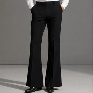 May include: Solid black trousers featuring a high-waisted design with a button closure and a distinct flared leg silhouette. The pants are tailored with a sharp center crease running down the front of each leg, extending from the waist to the hem.