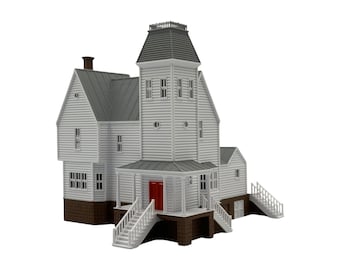 May include: A scale model of a two-story house featuring white horizontal siding, a gray mansard roof, and a brown foundation. The structure includes a central tower, a front porch with white railings, a set of stairs, and a bright red double door.