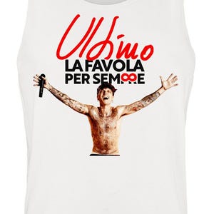 Può includere: Una canotta bianca con una stampa grafica di una persona tatuata con le braccia aperte che tiene un microfono. Sopra la figura, il testo rosso recita Ultimo, seguito dal testo nero LA FAVOLA PER SEMPRE con un simbolo di infinito.