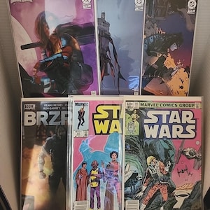 May include: A collection of six comic books in protective plastic sleeves. The top row features Wonder Woman, Batman, and a dark action scene. The bottom row includes BRZRKR, Star Wars issue 90, and Star Wars issue 66, showcasing various characters.