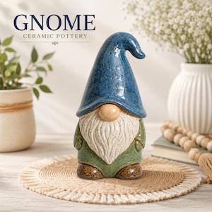 May include: A ceramic gnome figurine featuring a tall, speckled blue hat, a round beige nose, a textured white beard, a green tunic, and brown boots. The text GNOME CERAMIC POTTERY is visible in the upper left corner of the image.