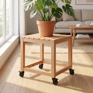 Könnte beinhalten: Ein quadratischer Pflanzenständer aus hellem Holz mit einer Oberfläche aus Holzlatten und vier schwarzen Lenkrollen an der Basis. Ein terrakottafarbener Topf mit einer grünen Monstera-Pflanze steht mittig auf dem Holzständer.