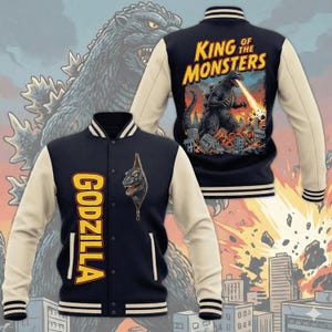 Könnte beinhalten: Eine marineblaue und cremefarbene Collegejacke mit Godzilla-Motiv. Die Vorderseite zeigt den Schriftzug GODZILLA und eine Reißverschlussgrafik mit einem Monsterkopf. Die Rückseite zeigt eine Godzilla-Illustration mit dem Text KING OF THE MONSTERS.