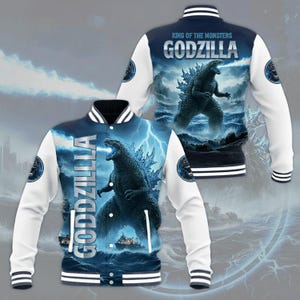 Op de afbeelding: Een varsity jack met een afbeelding van Godzilla die blauwe energie uitspuugt, inclusief de tekst Godzilla en King of the Monsters. Het jack heeft een donkerblauwe body met een stormachtige oceaan, witte mouwen en gestreepte boorden.