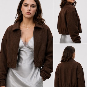 May include: A cropped dark brown jacket with a collared neckline, long sleeves with elasticated cuffs, and a front zip fastening. The jacket features a textured fabric finish and an elasticated hemline, shown from both the front and back views.