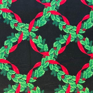 May include: A black fabric featuring a repeating pattern of circular wreaths made from green holly leaves, pine needles, and red berries, intertwined with a vibrant red ribbon that forms a continuous lattice design across the dark background.
