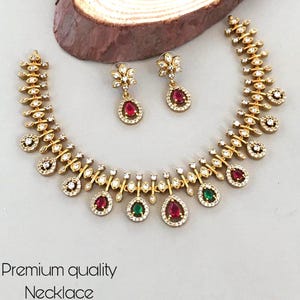 Conjunto de collar de diseño tradicional chapado en oro con circonitas blancas y pendientes colgantes de rubí. Regalo ideal.