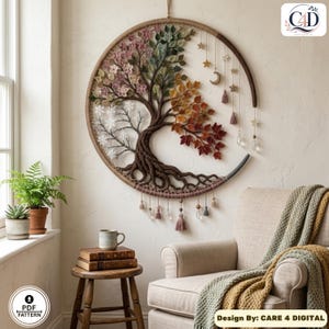 Puede incluir: Un tapiz circular con un dise&ntilde;o de &aacute;rbol de cuatro estaciones dentro de un aro de madera. El &aacute;rbol muestra flores rosas, hojas verdes, follaje oto&ntilde;al y ramas desnudas. Los elementos colgantes incluyen estrellas, una luna y borlas.