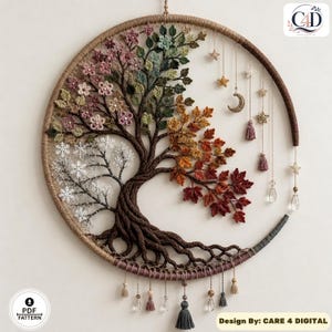 Può includere: Una decorazione da parete circolare con un albero all'uncinetto che rappresenta le quattro stagioni: fiori rosa, foglie verdi, fogliame autunnale arancione e rosso e fiocchi di neve bianchi. Il cerchio è avvolto in filo marrone con stelle.