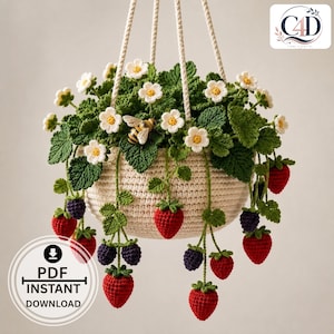Peut inclure: Un panier suspendu au crochet contenant une plante avec des feuilles vertes, des fleurs blanches et des baies rouges et violet foncé. Une petite abeille au crochet est fixée au feuillage. Le panier est suspendu par des cordons crème texturés.