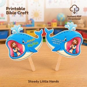 May include: Two blue whale paper crafts on wooden sticks. The left whale features the text Jonah and the Big Fish, while the right whale displays the text God Gives Us Another Chance. Jonah 3:1-2. Both show a cartoon figure inside the whale's mouth.