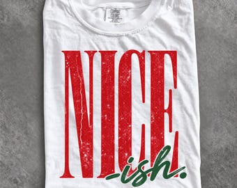 May include: A white short-sleeved t-shirt featuring the word NICE in large, distressed red capital letters. Below the word NICE, the word ish is printed in a smaller, cursive green font. The shirt has a Comfort Colors brand label at the neck.
